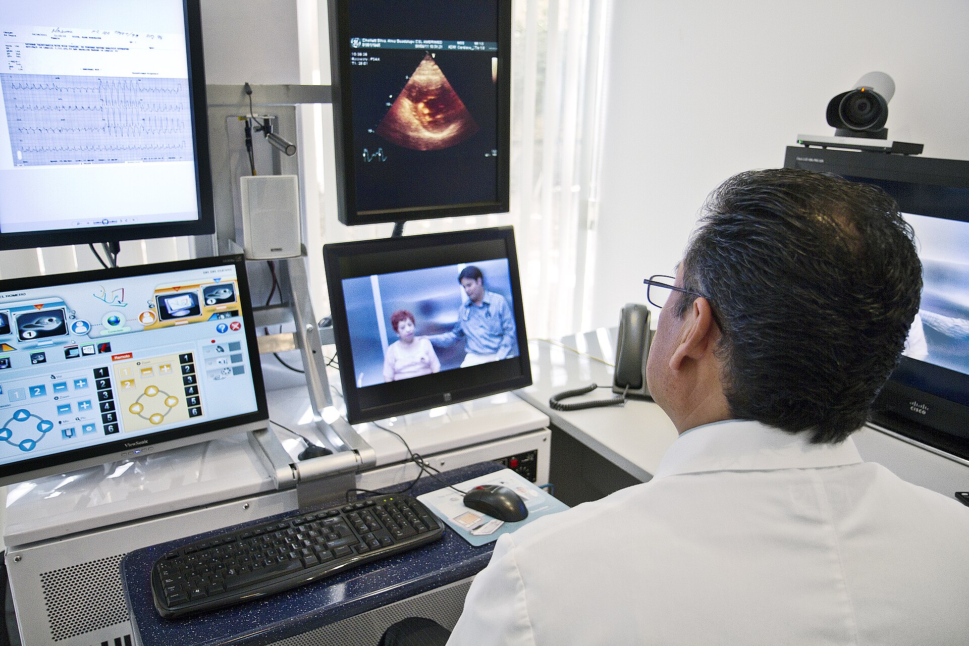 Doctor reviewing patient records and medical imaging on monitors